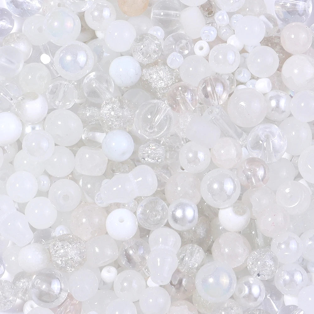 A close-up view of a mix of clear and milky white glass beads for DIY jewelry making