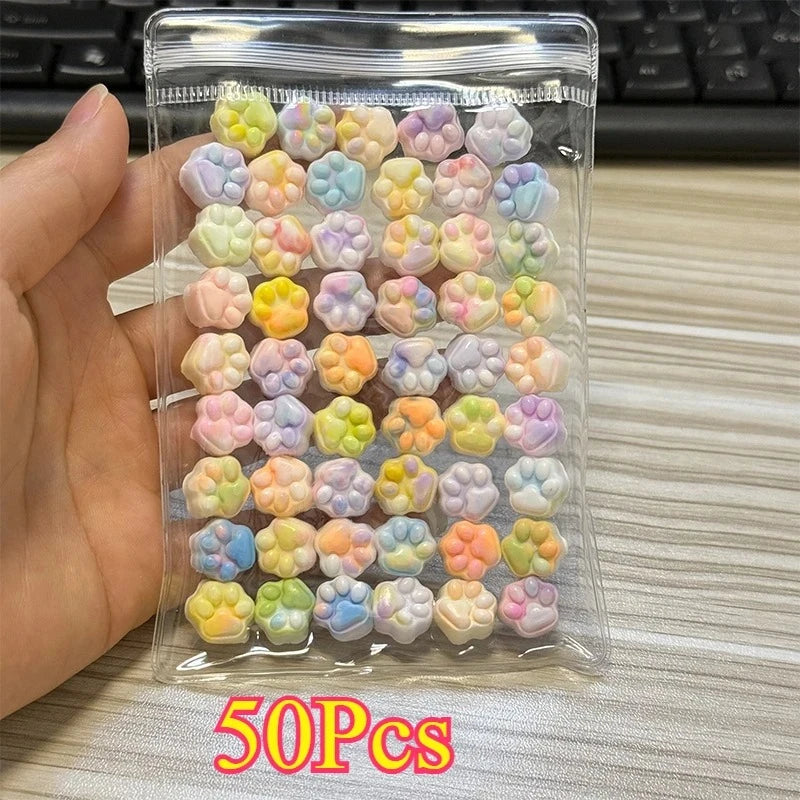 A clear plastic pouch filled with 50 colorful kawaii cat paw squishy stress relief fidget toys.
