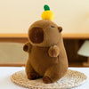 A brown capybara plush toy with a yellow head, sitting on a woven mat.