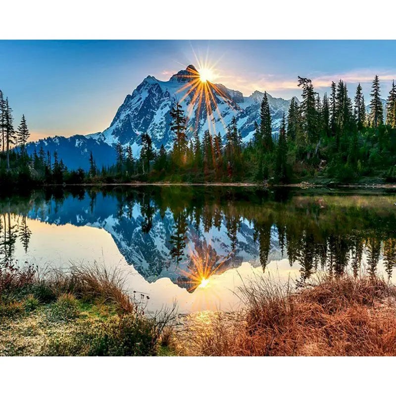 A scenic landscape featuring a mountain reflection on water with a sun flare in the sky.