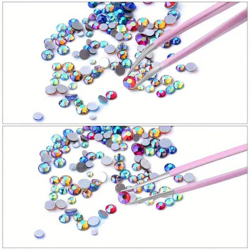 A collection of multi-size flat back acrylic rhinestones in various colors is shown being applied with tweezers for nail art 