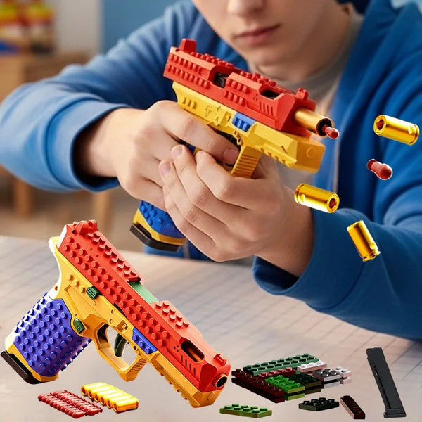 A person is holding and examining a red and yellow building block toy gun with various accessory pieces on a table.