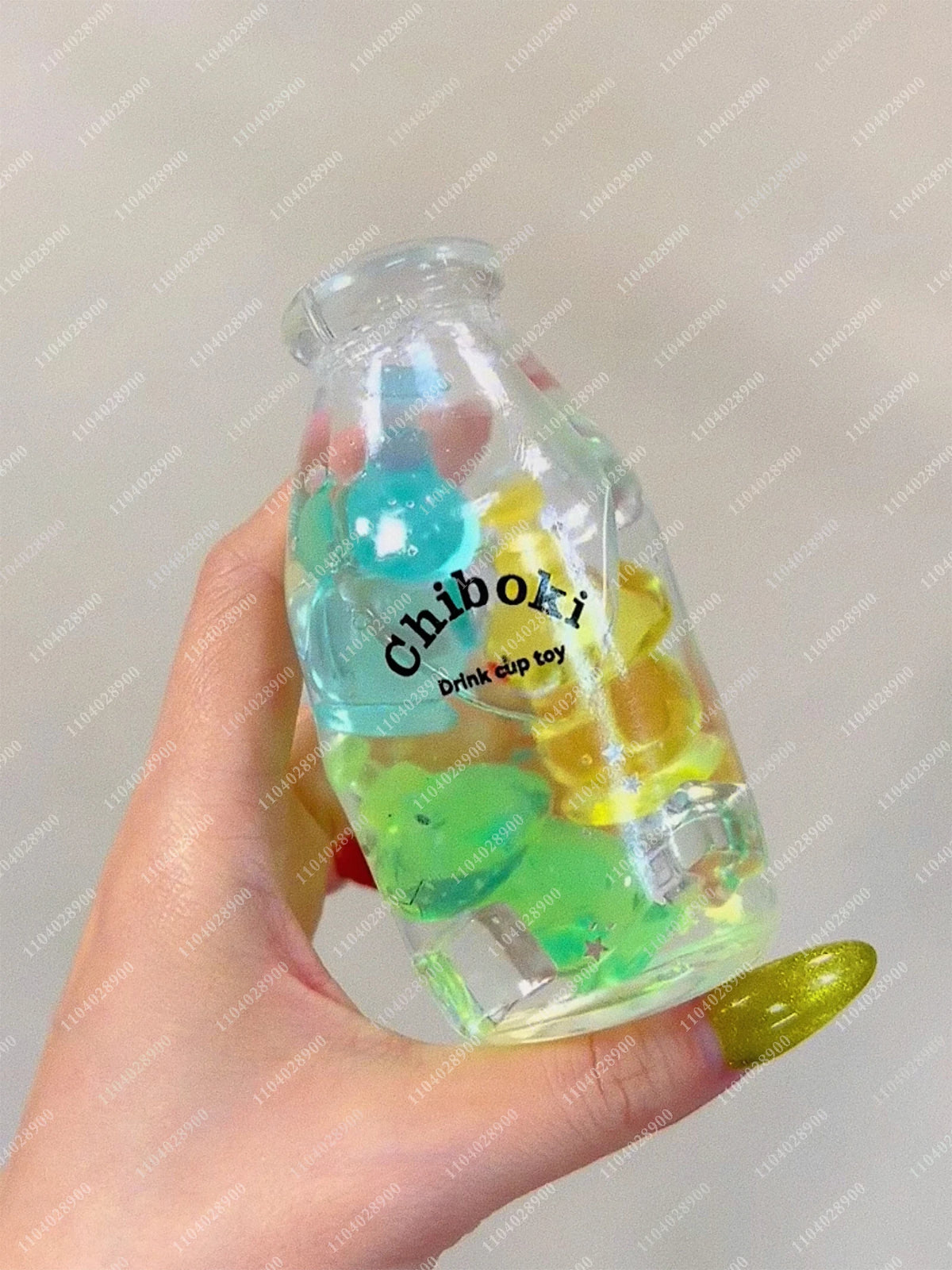 A hand holds a clear bottle filled with colorful squishy milk bottle stress balls for sensory relaxation.