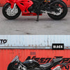 A red 1:18 scale die-cast motorcycle model of a classic sport bike replica shown in a studio setting.