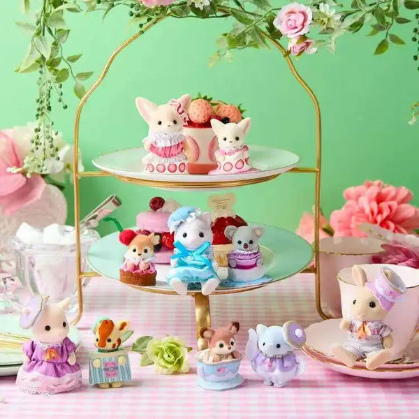 A collection of Sylvanian Families cutie tea party figures and accessories arranged on a pink table.