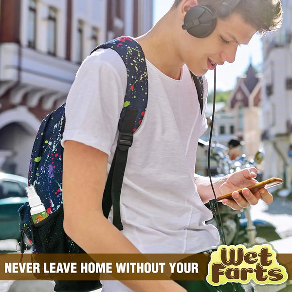 A young man wearing a white shirt and backpack is using a smartphone outdoors.