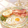 A plate of breakfast featuring fried eggs, bacon, and toast, set against a light background with sparkling accents.