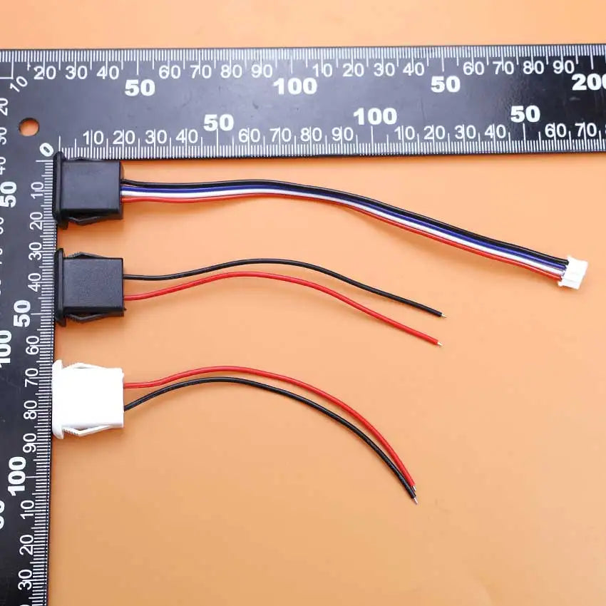 A set of three female power jack connectors with PH2.0 terminals and colored wires displayed next to a ruler.