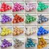 A collection of ten pearl acrylic D20 dice in various colors and patterns for role-playing games
