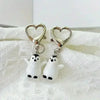A silver heart keychain set featuring two small white penguin charms