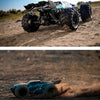 A blue brushless 4WD monster truck RC car with LED headlights driving on a sandy terrain.