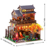 Miniature Japanese tea house DIY kit featuring a two-story wooden building with an orange tree and landscaping.