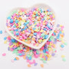 A heart-shaped dish filled with colorful polymer clay sprinkles for slime and craft decor
