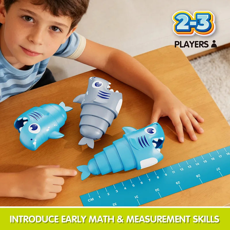 A child points to a blue plastic shark toy on a wooden table next to a ruler, demonstrating early math and measurement skills