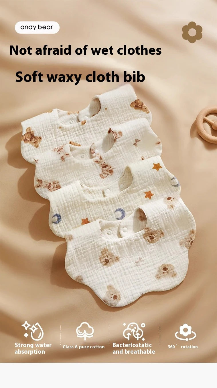 A stack of white soft waxy cloth bibs for babies, showing features like strong water absorption and breathable fabric.