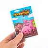 A hand holds a box of the Drecksau card game featuring a pink pig illustration.