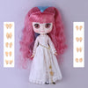 A pink-haired fashion doll with a pouty face wearing a white dress and gold jewelry.