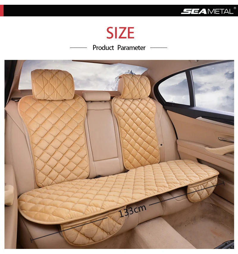 A beige car seat protector with a quilted pattern is shown installed in the back seat of a vehicle.