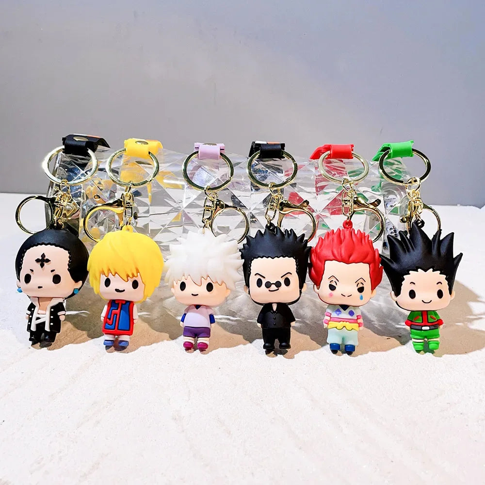 A collection of Hunter x Hunter anime character resin keychains with various hair colors and outfits displayed on a white sur