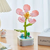 A set of pink rose flower building blocks arranged on a green stem and displayed in a white box.