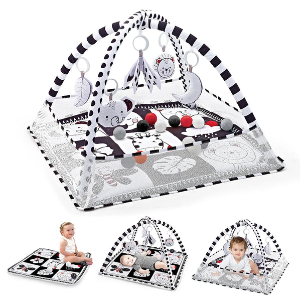 A baby play gym mat with a black and white patterned fabric featuring hanging pendants for infant development.