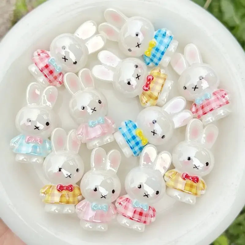 A collection of white resin bead phone charms shaped like bunnies with colorful accents.