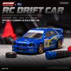 A blue 1:43 scale RC drift car is shown on a black surface with a tire nearby.