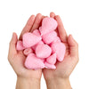 A pair of hands holds a cluster of pink silicone strawberry molds for crafting.