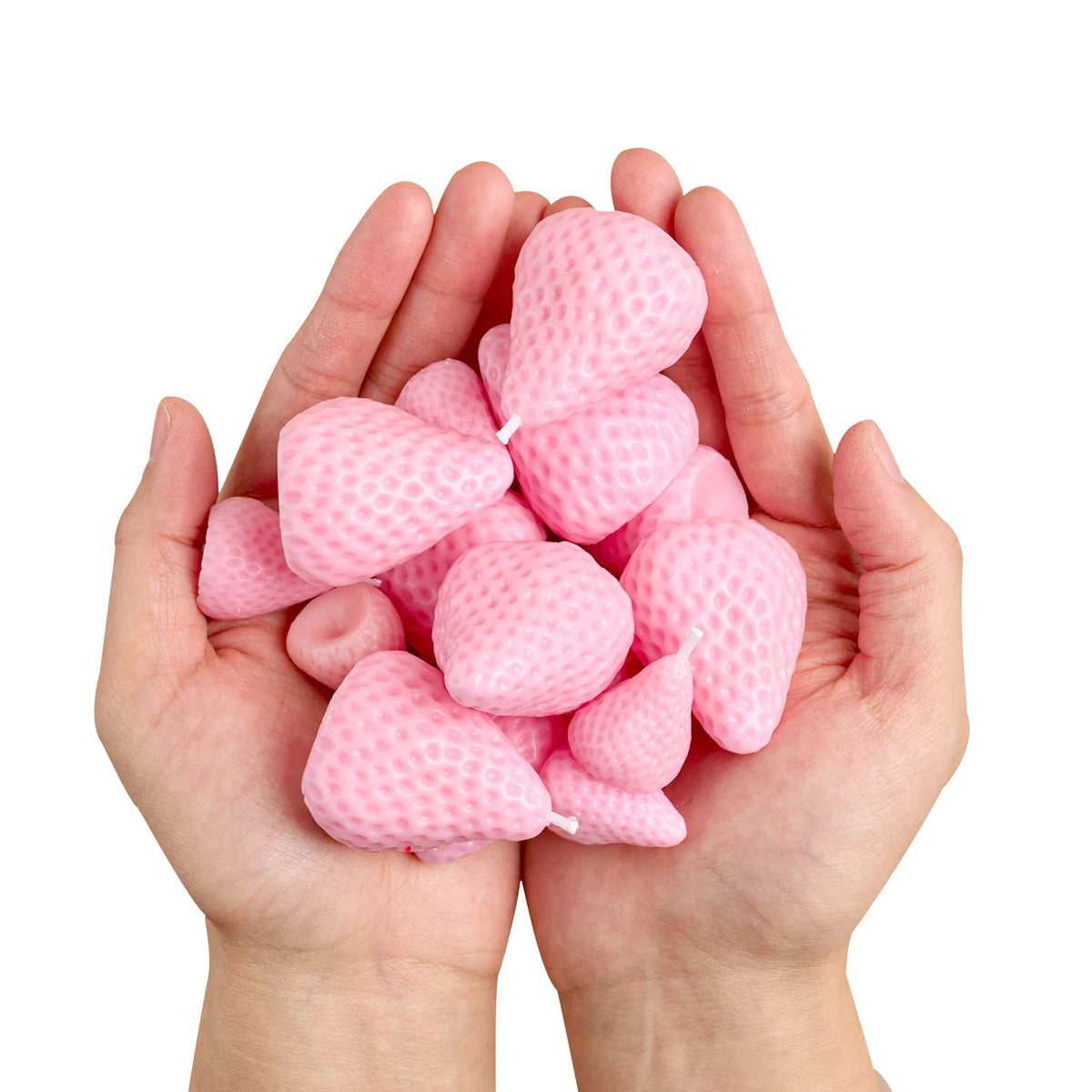 A pair of hands holds a cluster of pink silicone strawberry molds for crafting.