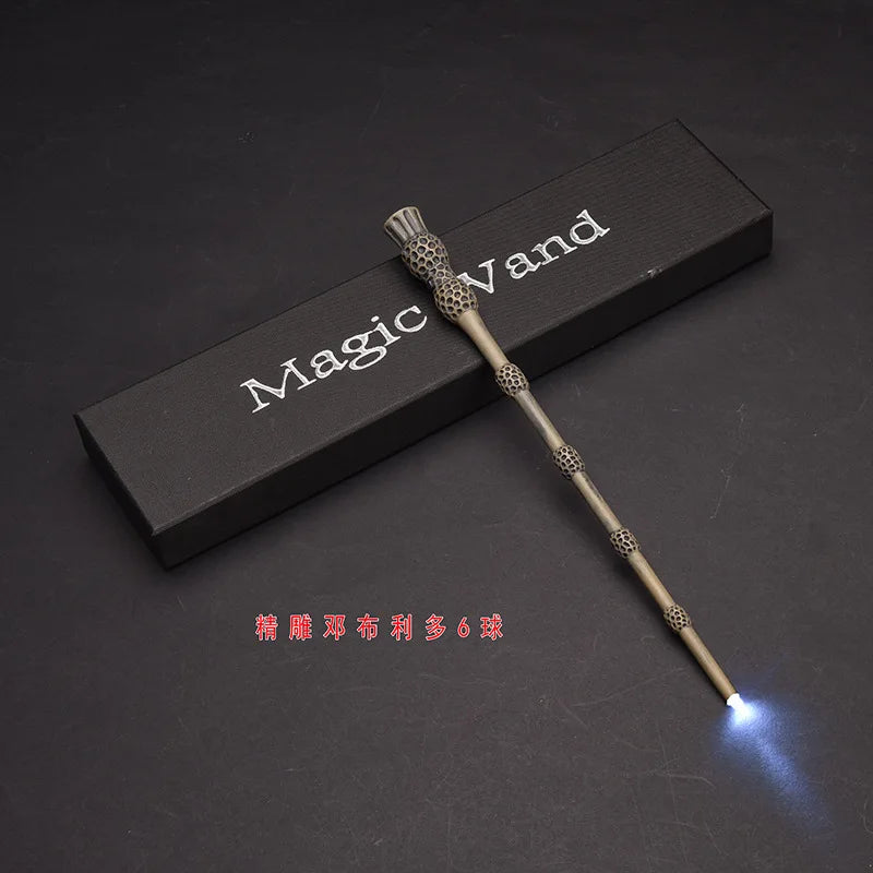 A slender, metallic magic wand with a glowing tip is displayed on a dark surface next to a rectangular box labeled Magic Wand