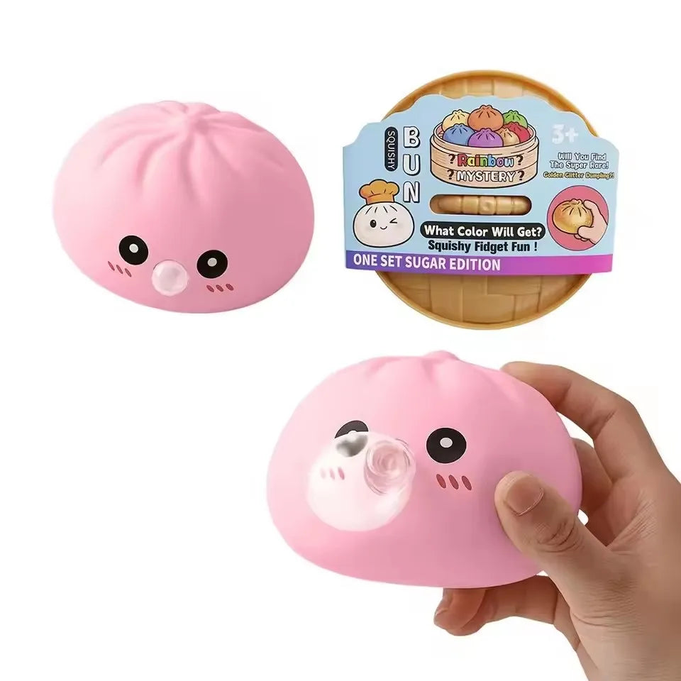 A pink squishy dumpling stress relief toy is shown in a hand, next to its packaging.
