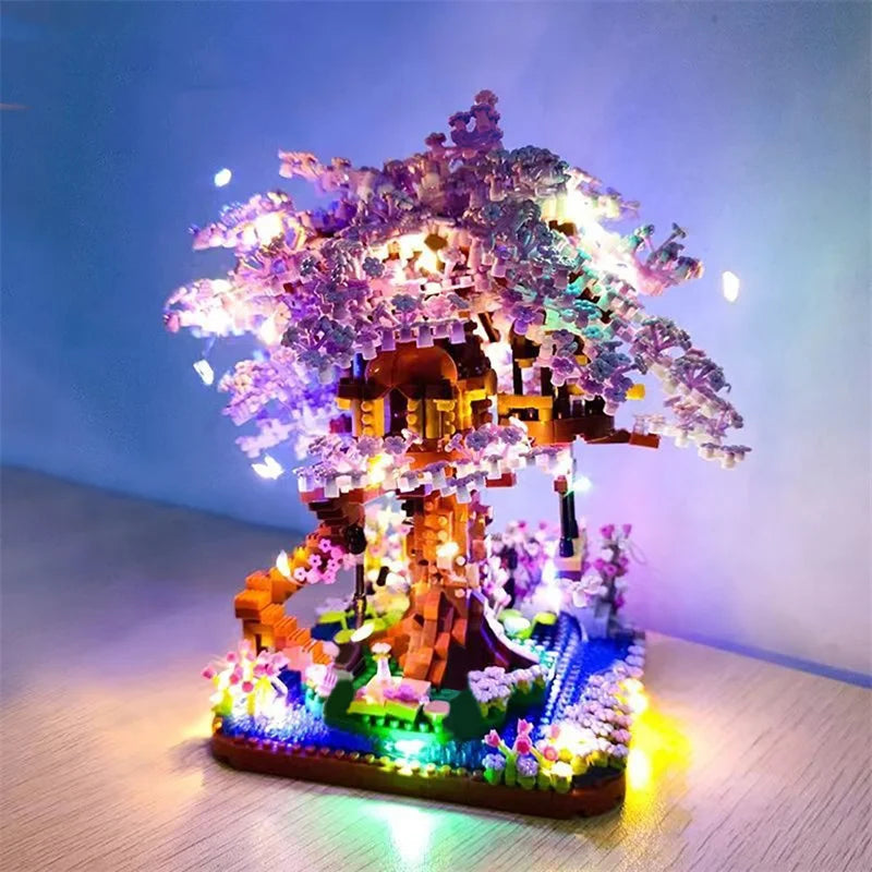 A miniature sakura tree built from blocks and illuminated with lights on a base.