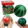 A green watermelon squishy stress ball is shown in its box and being held by a hand.
