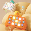 An orange Montessori busy board with LED light switches is shown resting on a beige fabric.