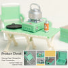 A miniature camping picnic set with a green carrying case and accessories displayed on a light wooden chair.