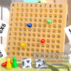 A yellow multiplication board game with numbered tiles, colorful pieces, and a dice.