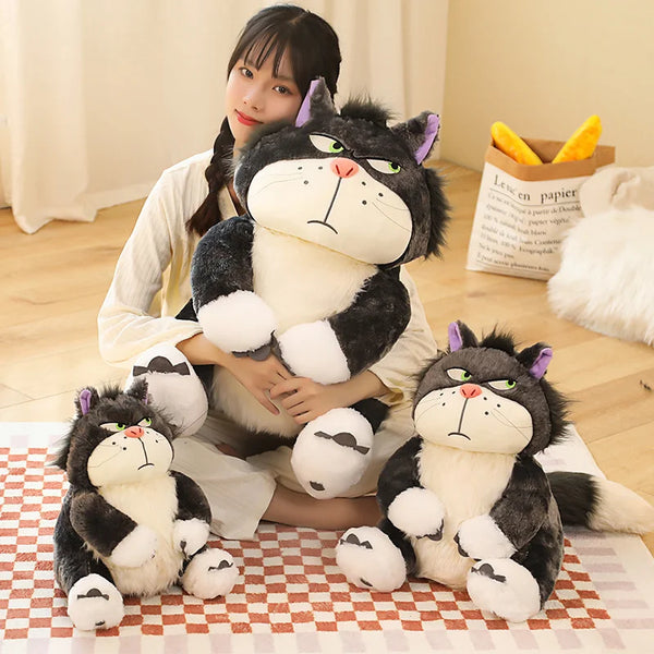 A plush toy of a black and white cat named Lucifer sitting on a checkered mat.