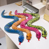A collection of lifelike simulation snake plush toys in various colors and patterns laid out on a white surface.