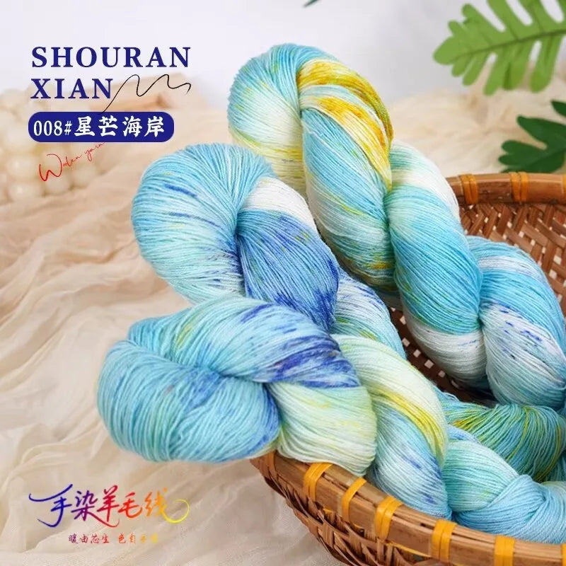 A skein of hand-dyed Australian wool yarn featuring a blue and yellow gradient, coiled in a basket.
