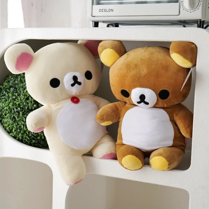 A pair of Rilakkuma anime plush bears in beige and brown colors sitting side by side.