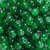A close-up view of small, round, green glass beads for DIY jewelry making.