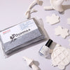 A package of OUMMAA rock clay modeling clay next to several white sculpted clay shapes.