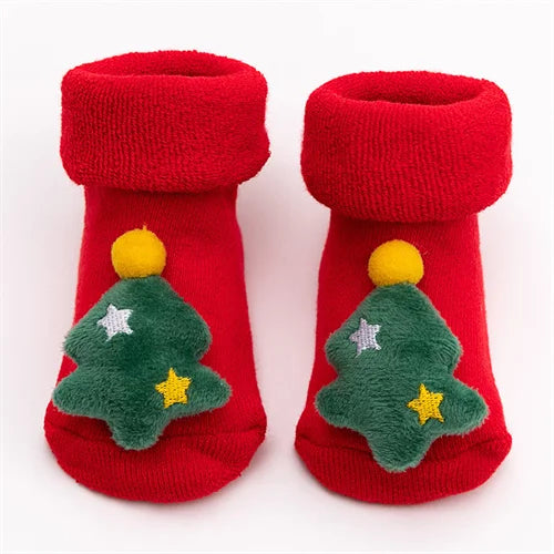Pair of red baby anti-slip cotton socks with festive green Christmas tree designs