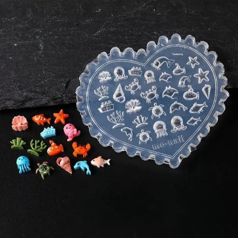 A clear silicone mold heart shaped with various sea and ocean creature designs for nail art.