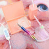 An electric diamond painting pen kit with a pink tool and a white suction tool displayed on a textured background.