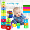 A baby is playing with a colorful stacking cup game featuring letters and numbers like A, B, C, D, E, F, G, H, and 1 through 