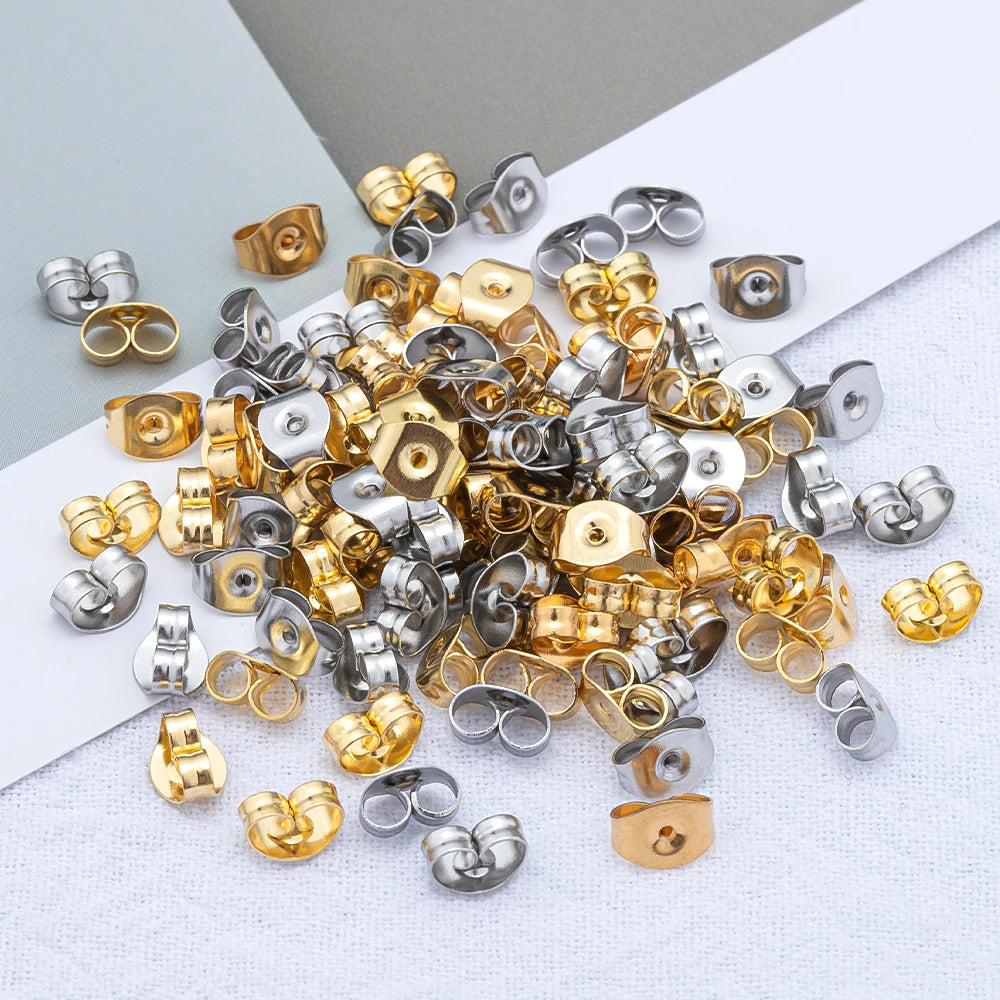 A collection of various stainless steel and gold-toned earring stud bases and backs for DIY jewelry making.