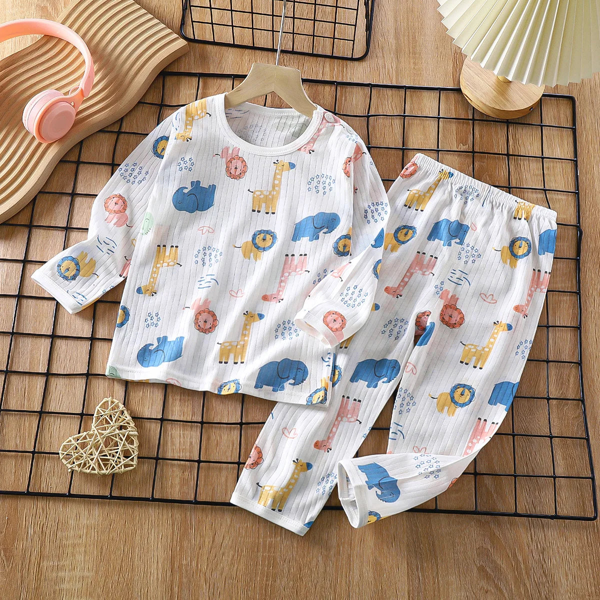 White cotton pajama set for kids featuring a pattern of cute animals like elephants and giraffes