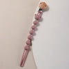 A silicone pacifier clip featuring a wooden bear paw top and a string of pink silicone beads.