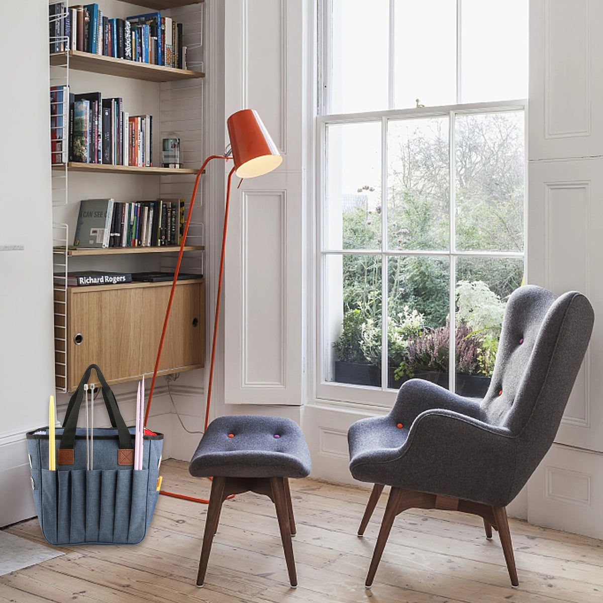 A gray upholstered armchair sits next to a white cabinet and a wooden shelf unit in a bright room.